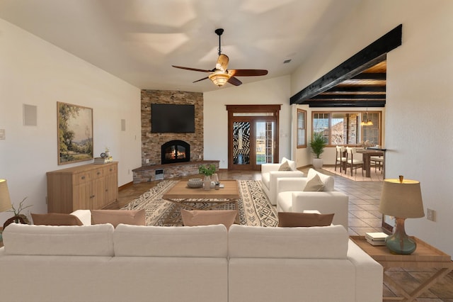 living room with ceiling fan, tile patterned flooring, and a stone fireplace