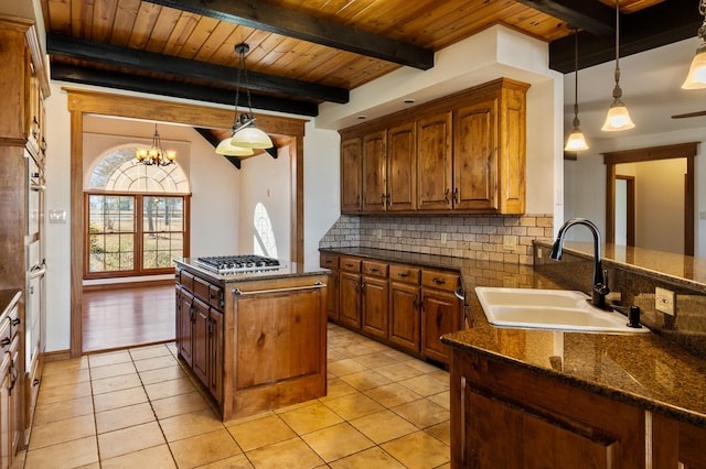 kitchen with sink, tasteful backsplash, a center island, and pendant lighting