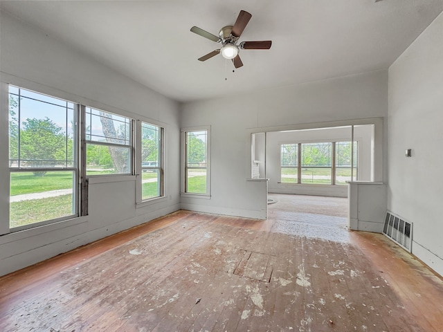 unfurnished living room featuring visible vents, ceiling fan, and hardwood / wood-style flooring