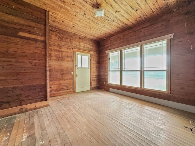 spare room featuring plenty of natural light, wood ceiling, wooden walls, and wood-type flooring