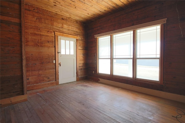 interior space featuring wooden ceiling, hardwood / wood-style floors, and wooden walls