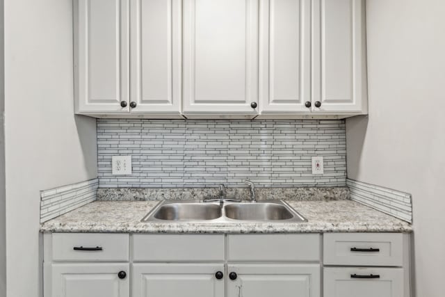 kitchen with sink, white cabinets, and tasteful backsplash