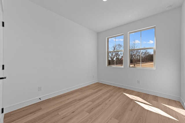 spare room with light wood-type flooring and baseboards