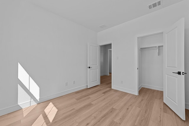 unfurnished bedroom featuring light wood-style flooring, visible vents, and baseboards