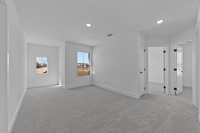 unfurnished room with recessed lighting, visible vents, baseboards, and light colored carpet