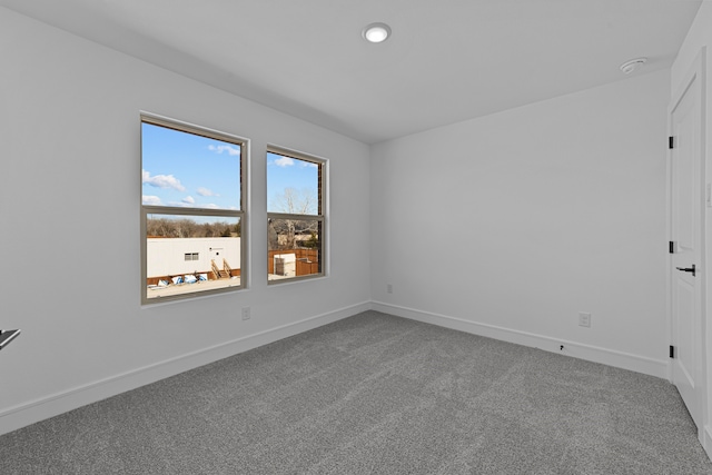 carpeted empty room featuring baseboards