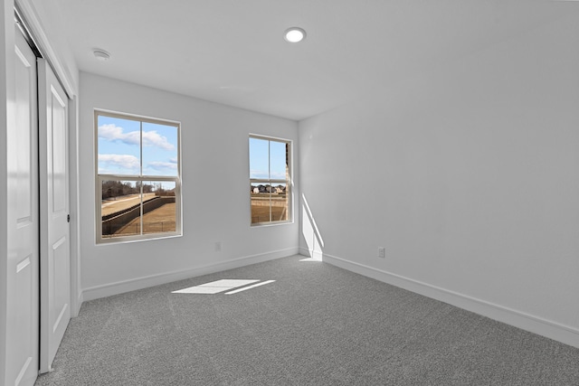 empty room featuring baseboards, carpet flooring, and recessed lighting