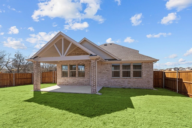 rear view of property featuring a patio area, a fenced backyard, a lawn, and brick siding