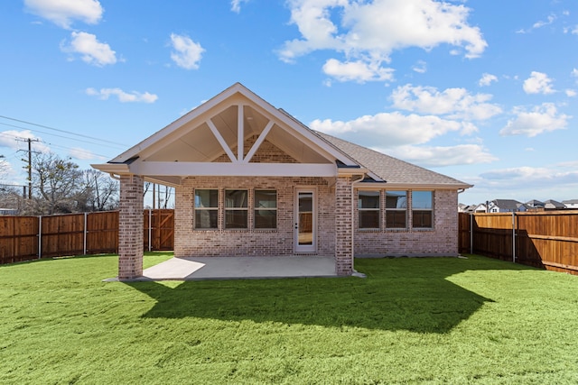 rear view of house featuring a fenced backyard, a lawn, a patio, and brick siding