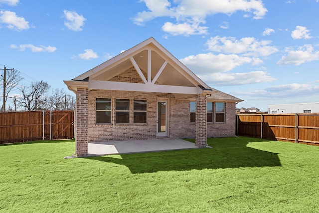 rear view of house featuring a patio area, a fenced backyard, a lawn, and brick siding