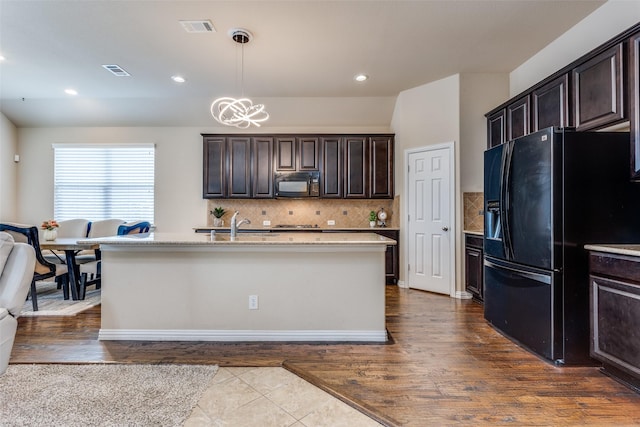 kitchen featuring black appliances, tasteful backsplash, visible vents, and dark brown cabinets