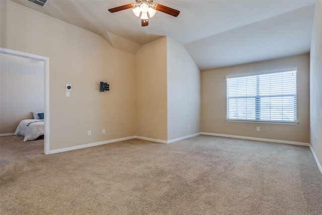 unfurnished living room featuring vaulted ceiling, ceiling fan, and light carpet