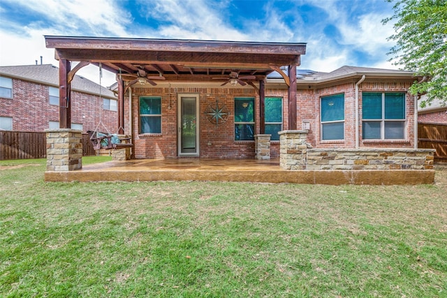 rear view of property with ceiling fan, a yard, and a patio