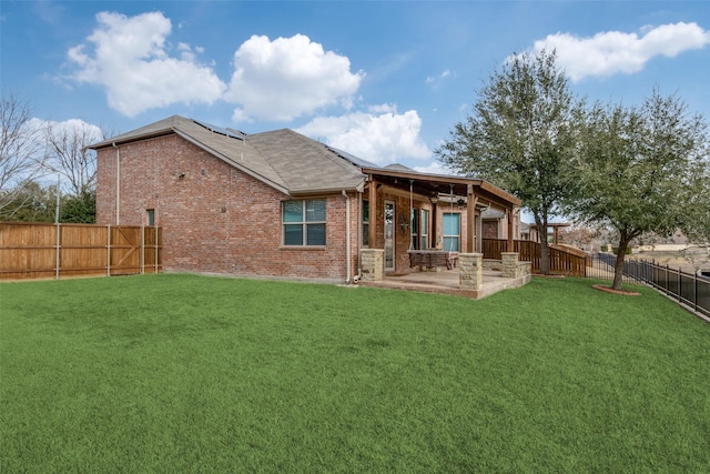 rear view of property featuring a lawn and a patio