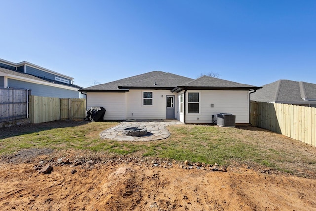 rear view of house with an outdoor fire pit, central AC unit, a patio area, and a lawn