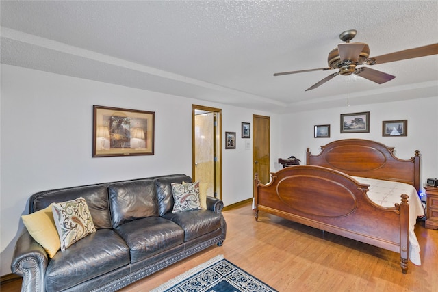 bedroom with ceiling fan, wood finished floors, and a textured ceiling