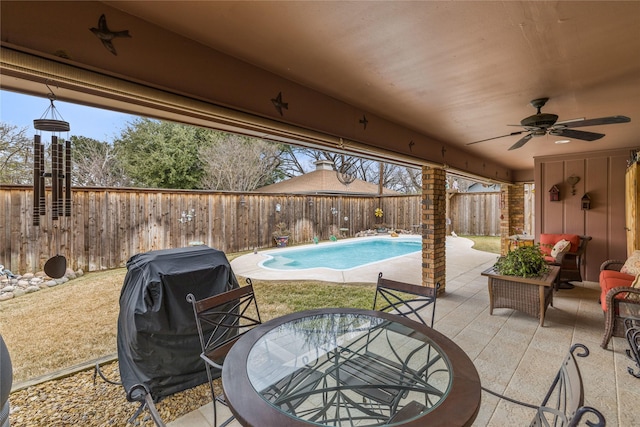 view of patio featuring a fenced in pool, outdoor dining area, a fenced backyard, ceiling fan, and grilling area