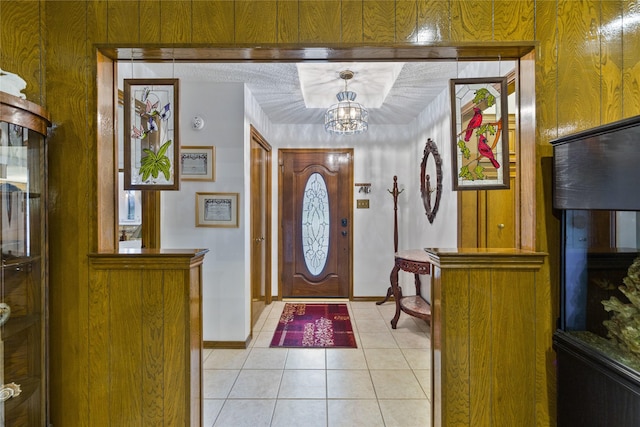 tiled foyer featuring an inviting chandelier