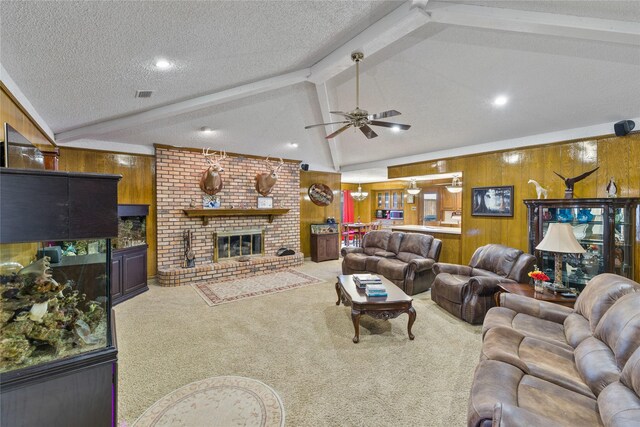 carpeted living room with wooden walls, a fireplace, lofted ceiling with beams, ceiling fan, and a textured ceiling