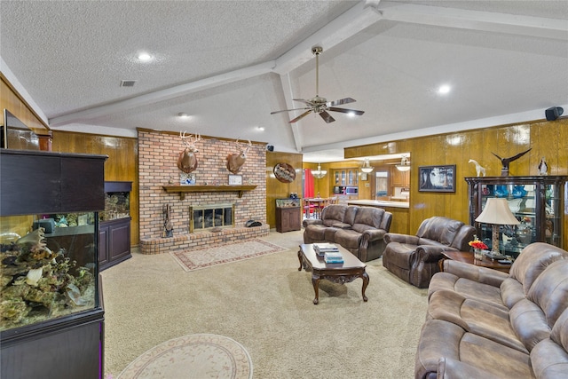 living room with a fireplace, wooden walls, carpet, and a textured ceiling