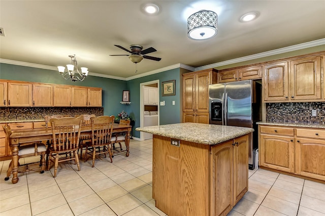 kitchen with decorative light fixtures, a center island, light tile patterned flooring, stainless steel fridge with ice dispenser, and ornamental molding