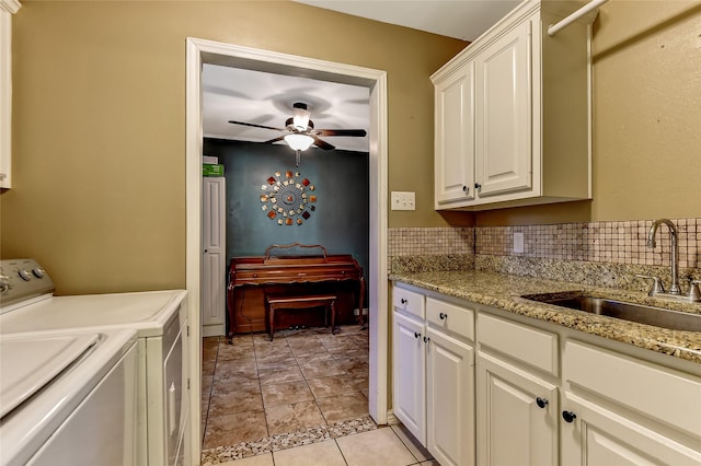 interior space featuring cabinets, washing machine and clothes dryer, sink, ceiling fan, and light tile patterned floors