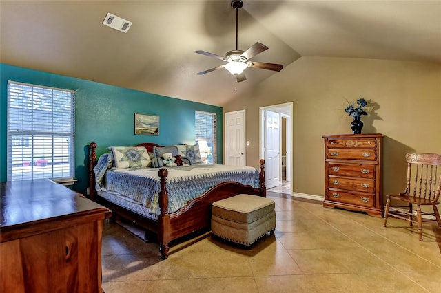 bedroom featuring ceiling fan, light tile patterned floors, ensuite bath, and vaulted ceiling