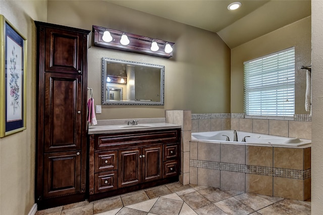 bathroom featuring lofted ceiling, vanity, tile patterned flooring, and a relaxing tiled tub