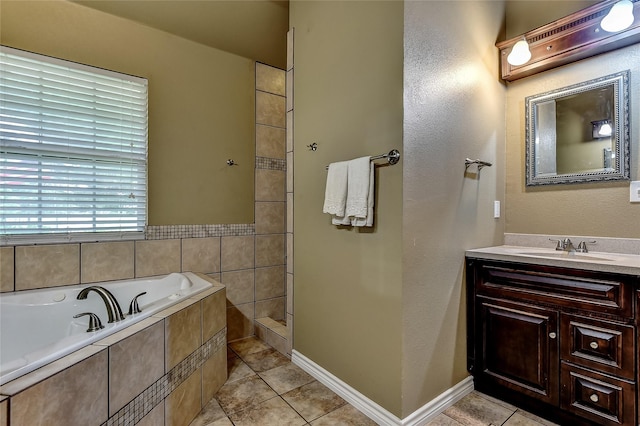 bathroom with tiled bath, vanity, and tile patterned flooring