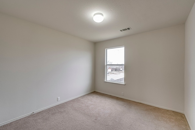 carpeted spare room featuring a textured ceiling