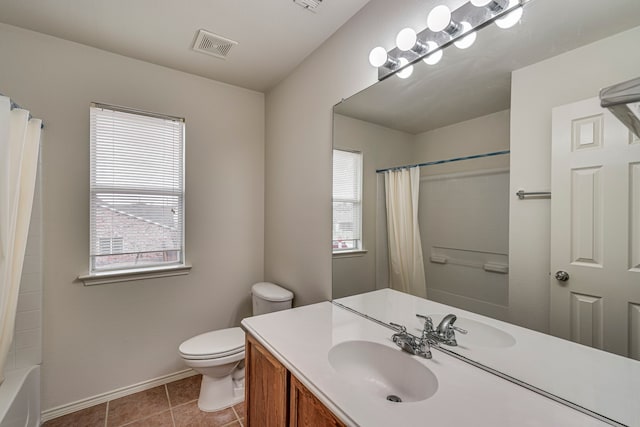 full bathroom featuring tile patterned flooring, toilet, vanity, and a healthy amount of sunlight