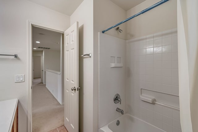 bathroom with tiled shower / bath combo and vanity