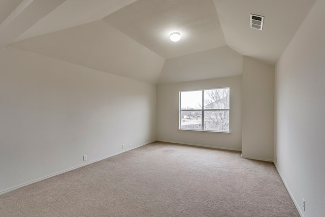 spare room with lofted ceiling and light carpet