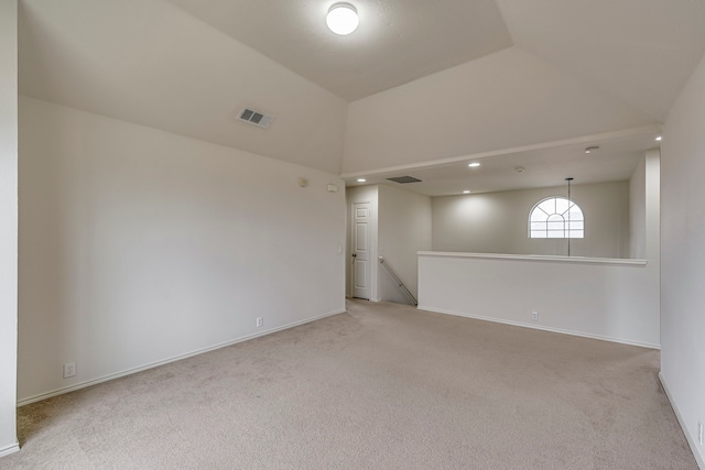 carpeted empty room with lofted ceiling