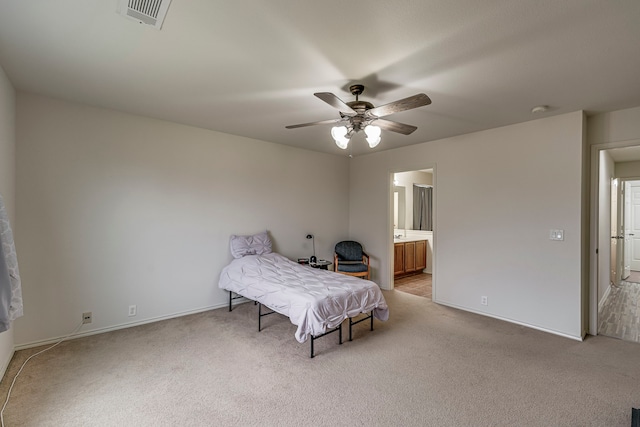 bedroom featuring ceiling fan, connected bathroom, and light carpet