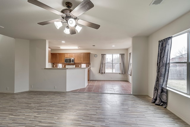 unfurnished living room with ceiling fan