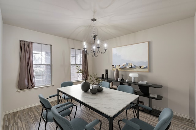 dining space featuring wood-type flooring and a chandelier