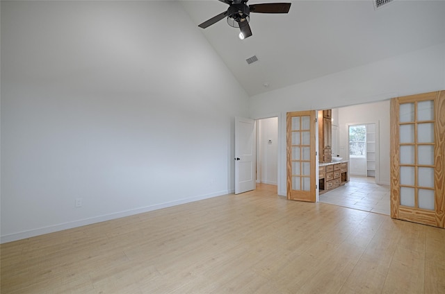 unfurnished room with ceiling fan, light hardwood / wood-style floors, french doors, and high vaulted ceiling