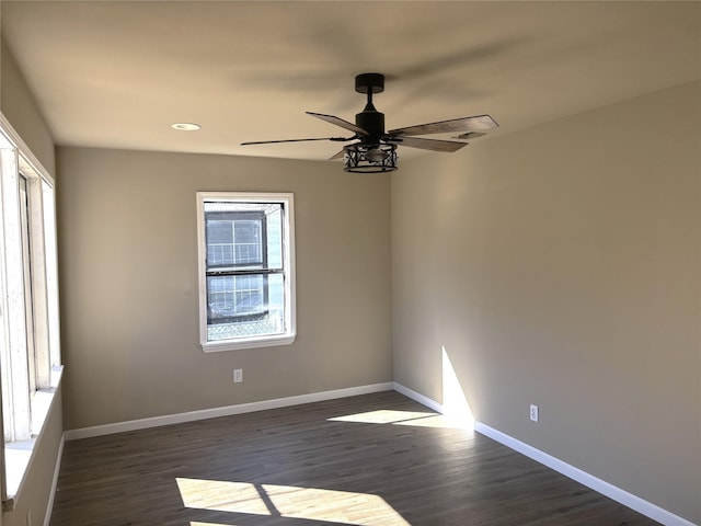 empty room featuring dark wood-type flooring and ceiling fan