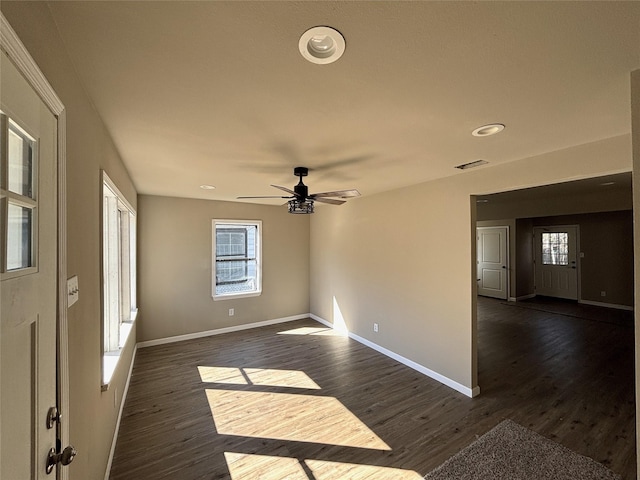 empty room with ceiling fan and dark hardwood / wood-style flooring