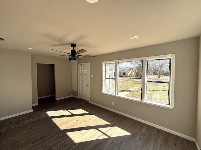 unfurnished room with ceiling fan and dark wood-type flooring