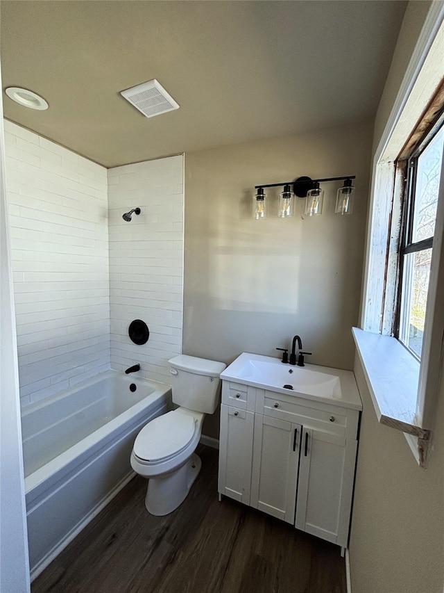 full bathroom with wood-type flooring, toilet, vanity, and tiled shower / bath