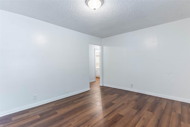 spare room featuring dark hardwood / wood-style floors and a textured ceiling