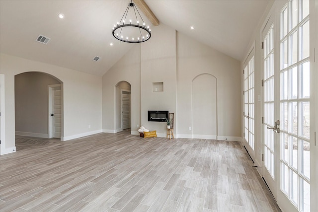 unfurnished living room with high vaulted ceiling, light wood-type flooring, a notable chandelier, and beamed ceiling