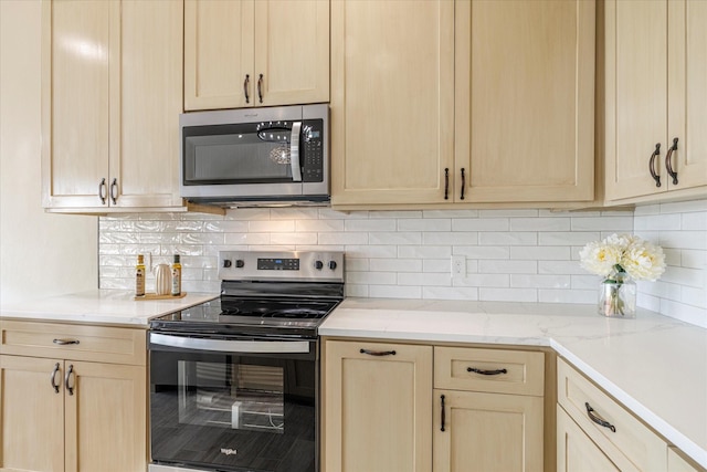 kitchen with appliances with stainless steel finishes, light brown cabinetry, and tasteful backsplash