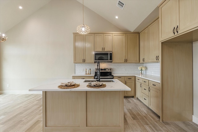 kitchen featuring decorative light fixtures, sink, light wood-type flooring, light brown cabinets, and stainless steel appliances