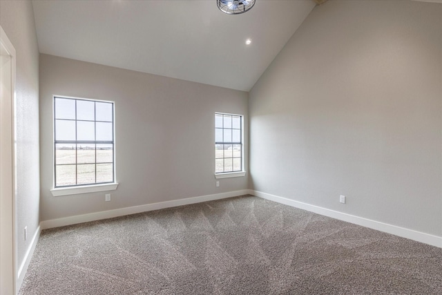 spare room featuring carpet and high vaulted ceiling