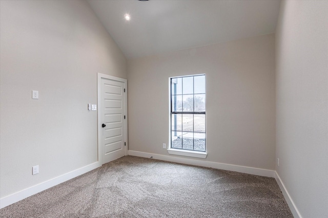 carpeted empty room with vaulted ceiling