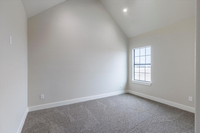 empty room featuring carpet floors and high vaulted ceiling