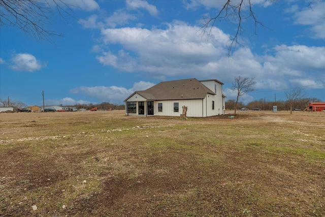 rear view of property featuring a lawn